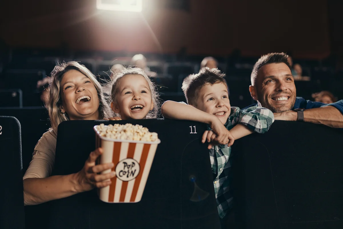 Happy family enjoying while watching a movie in cinema