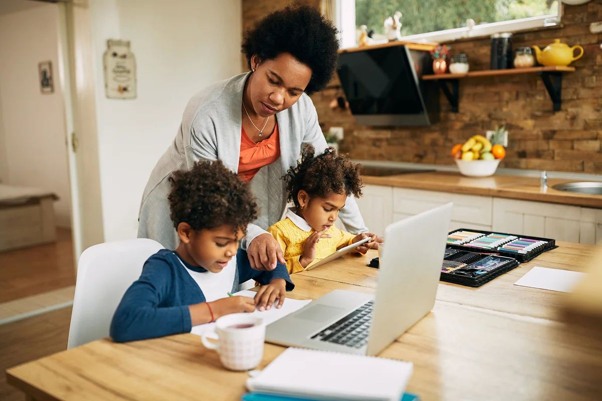 mother assisting her kids in learning at home