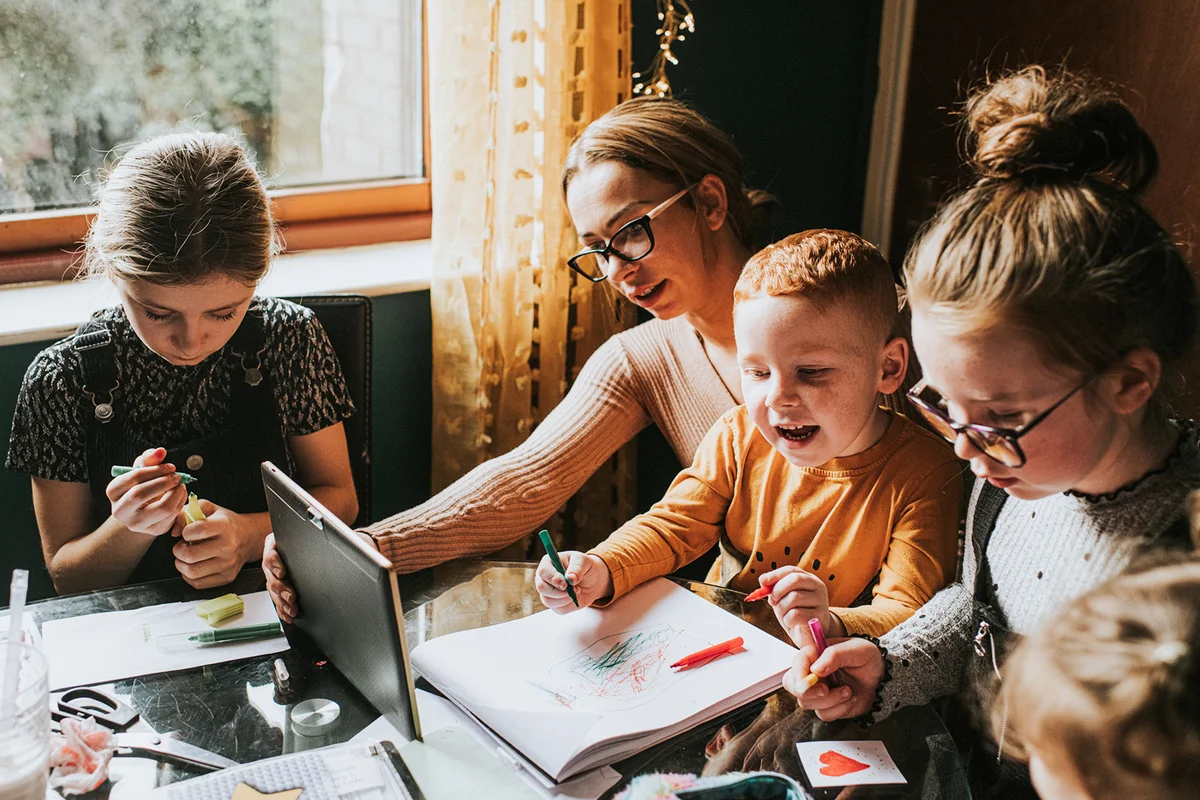 Mother Homeschooling her Children while using a Digital Tablet
