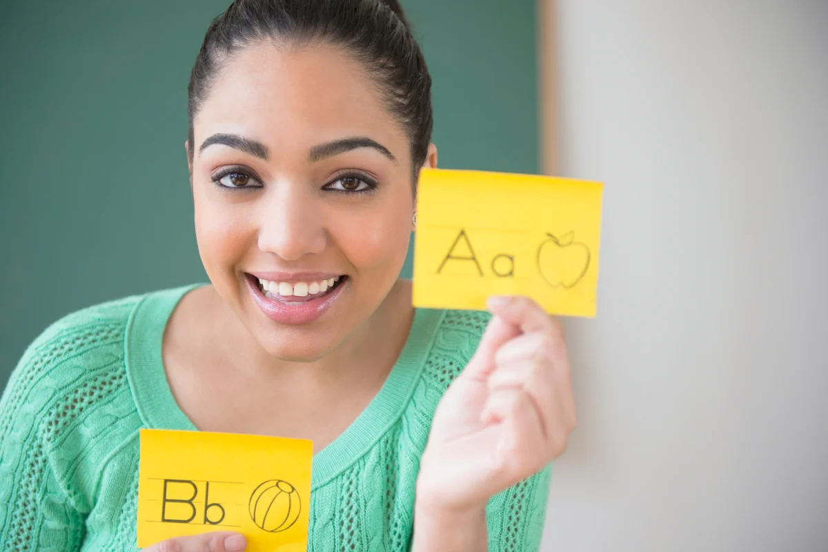 Hispanic teacher using flash cards with letter A