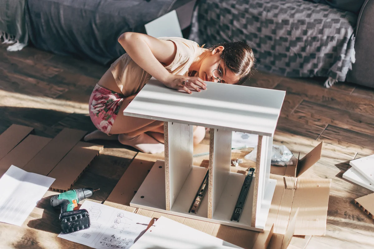 woman building furniture on the floor