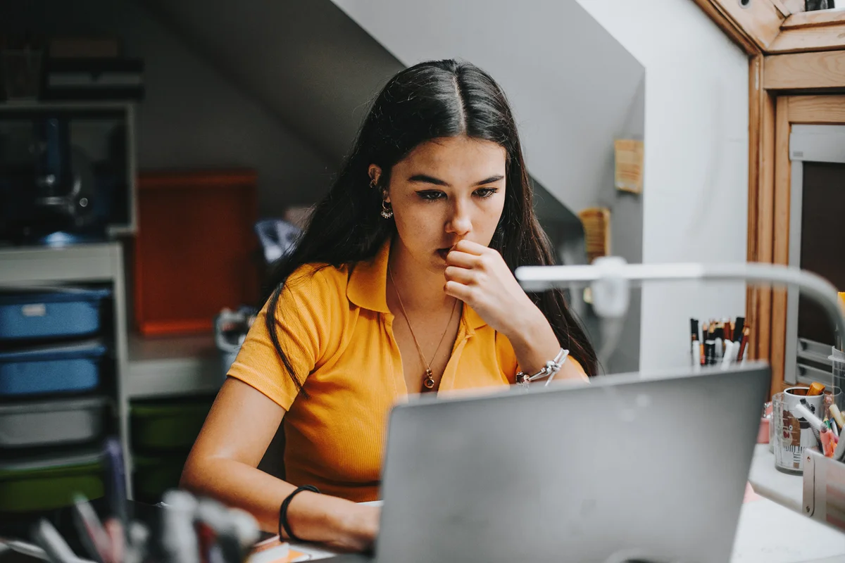 college student doing some home works from home with laptop