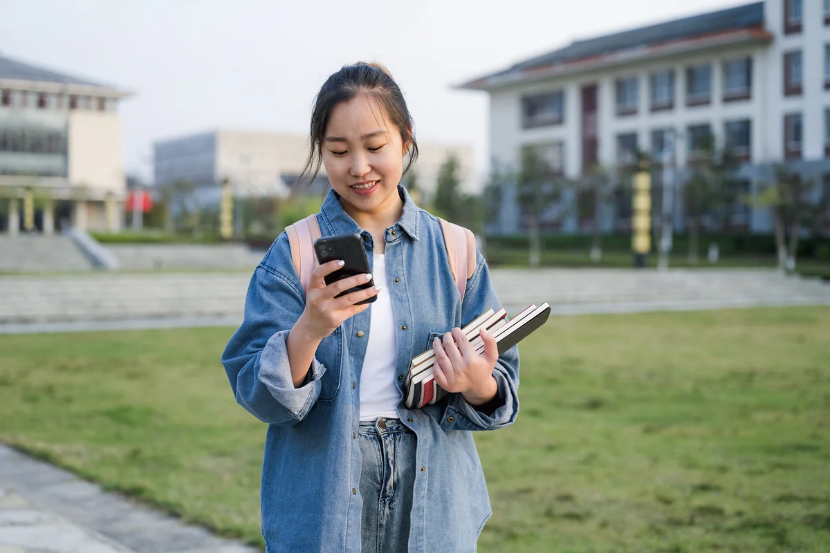 A female college student uses her mobile phone on campus