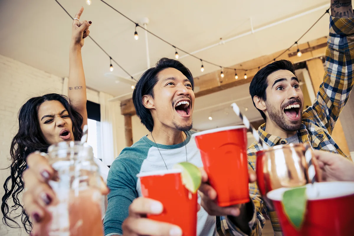Friends cheering while watching sports match on TV