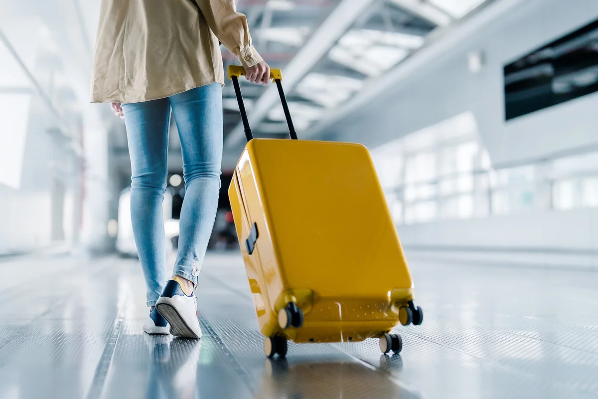 woman with luggage walking in airport