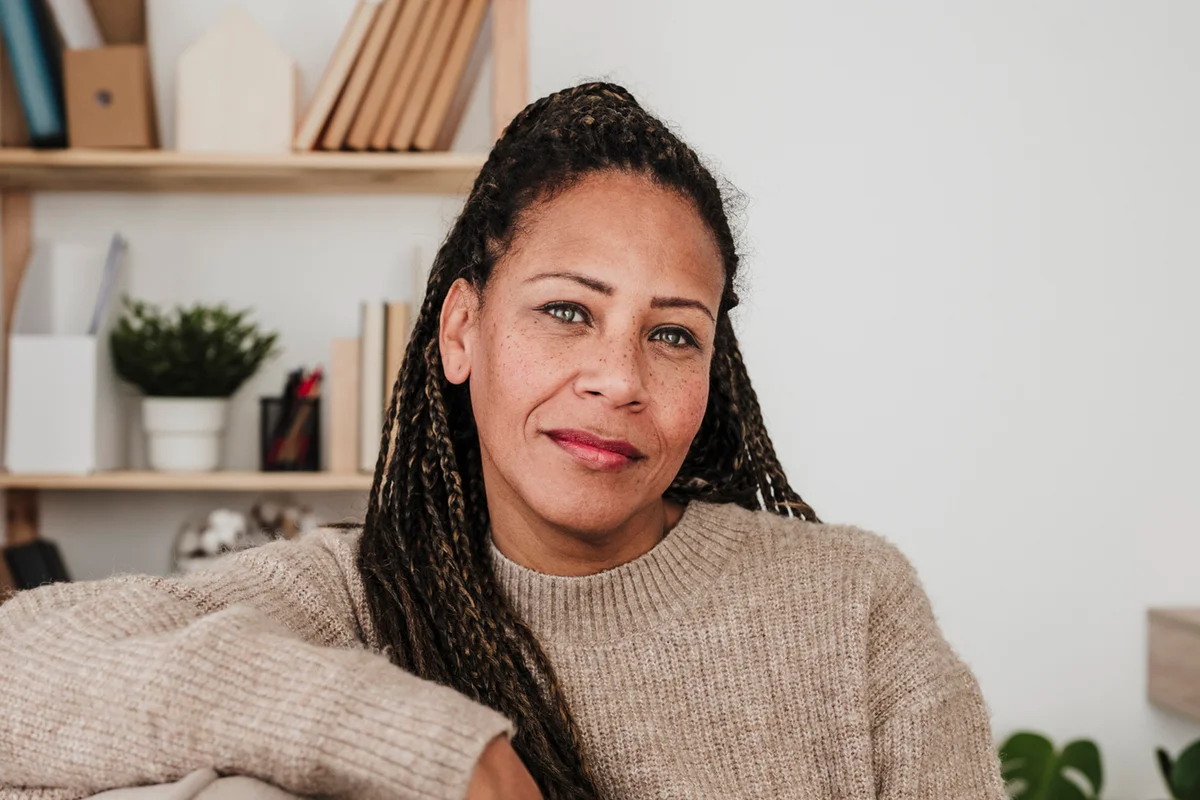 Smiling woman sitting on sofa at home