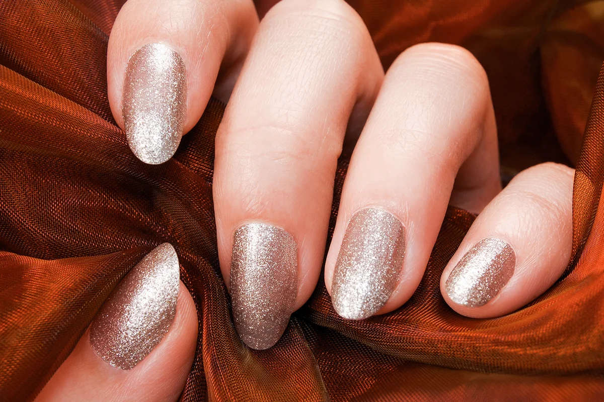 woman fingers with nail art manicure with nude colour
