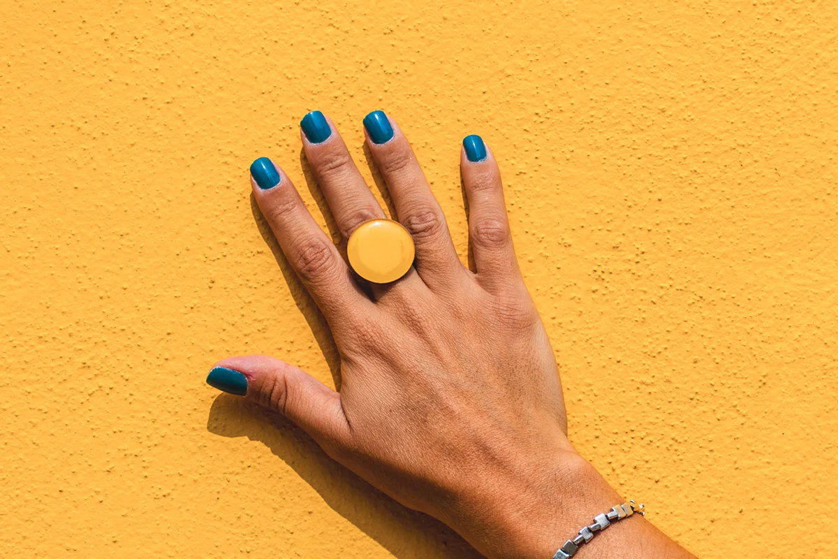 hands against yellow wall