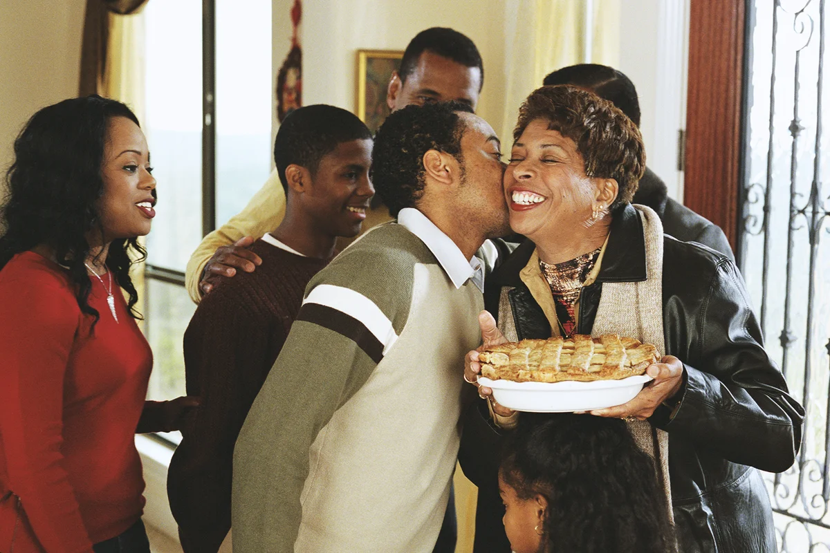 Family greeting grandparents at door, smiling