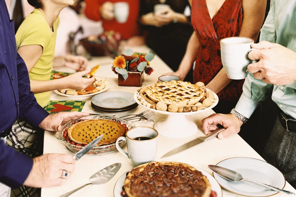 Family Stand Round a Dessert Table in a Dining Room