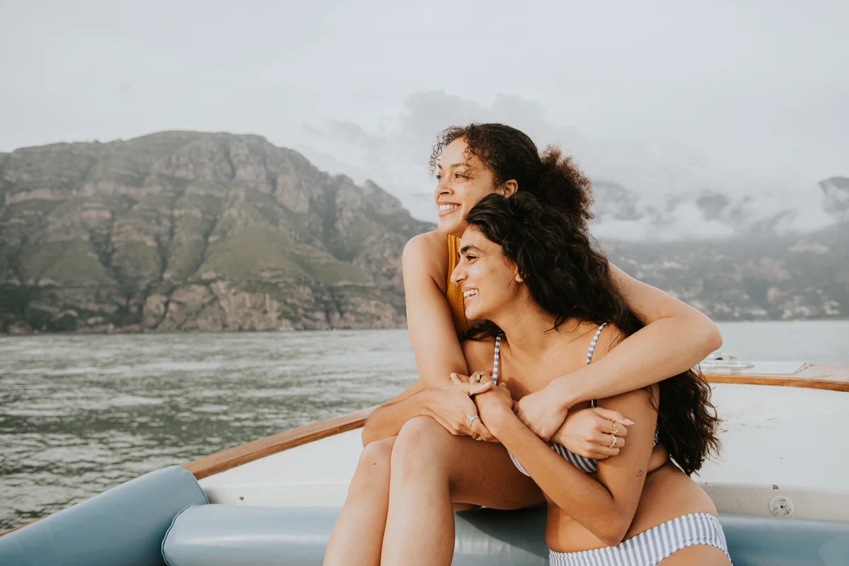 Two woman embrace during a romantic boat ride