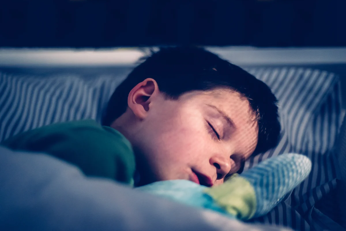 Boy sleeping in dark room