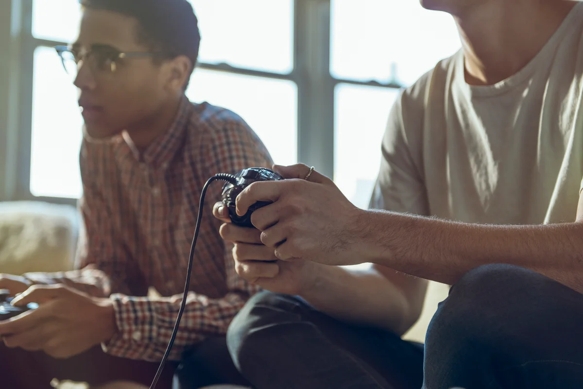 Male friends playing video game at home