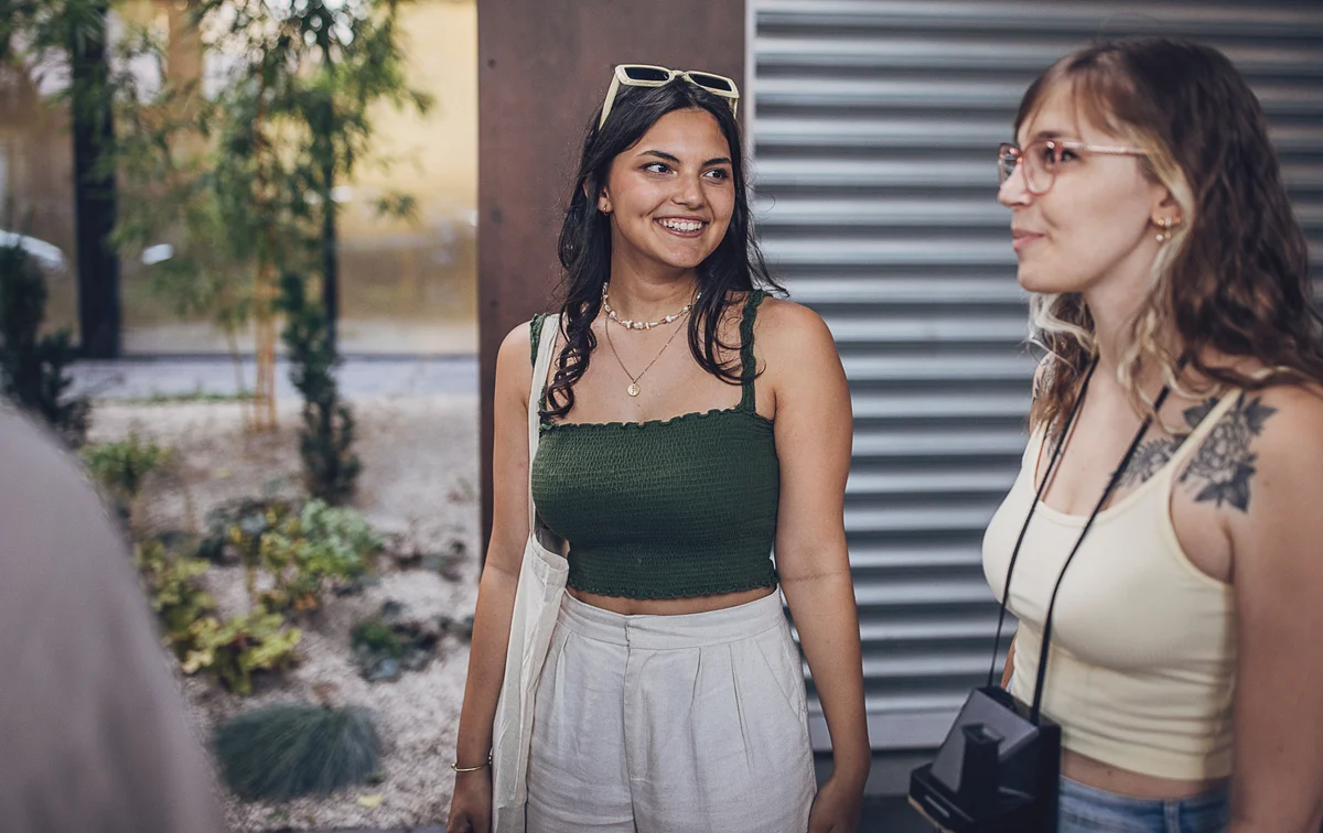 Two people, young women friends together in city.