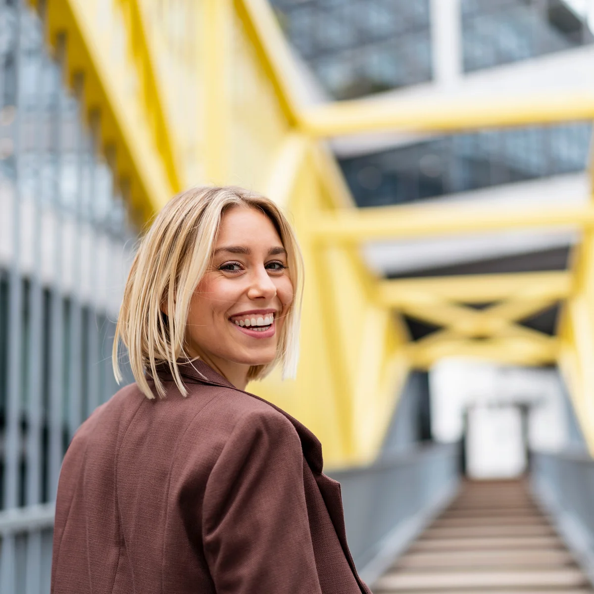 Portrait of happy young woman on a bridge in the city