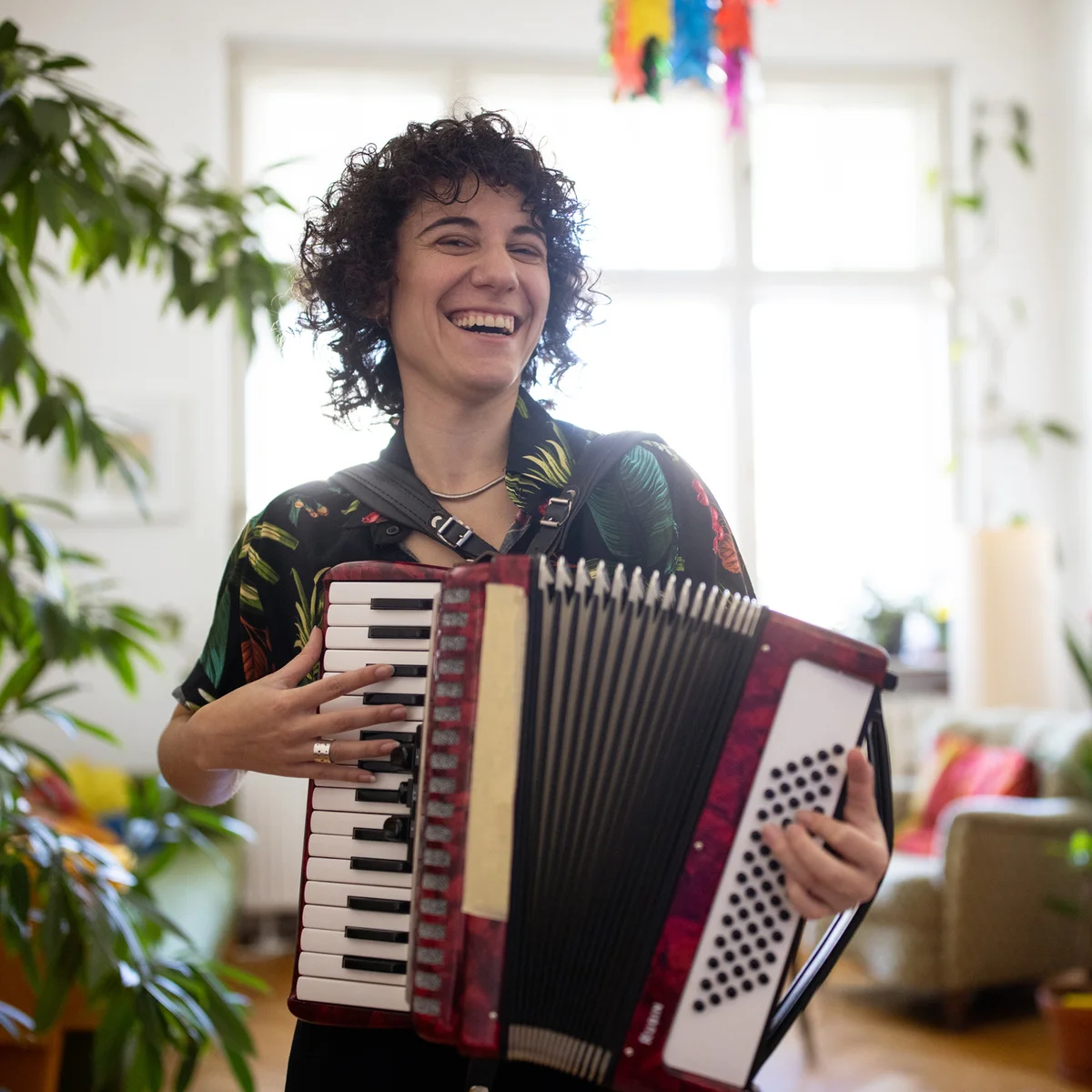 Non-binary person enjoying playing accordion