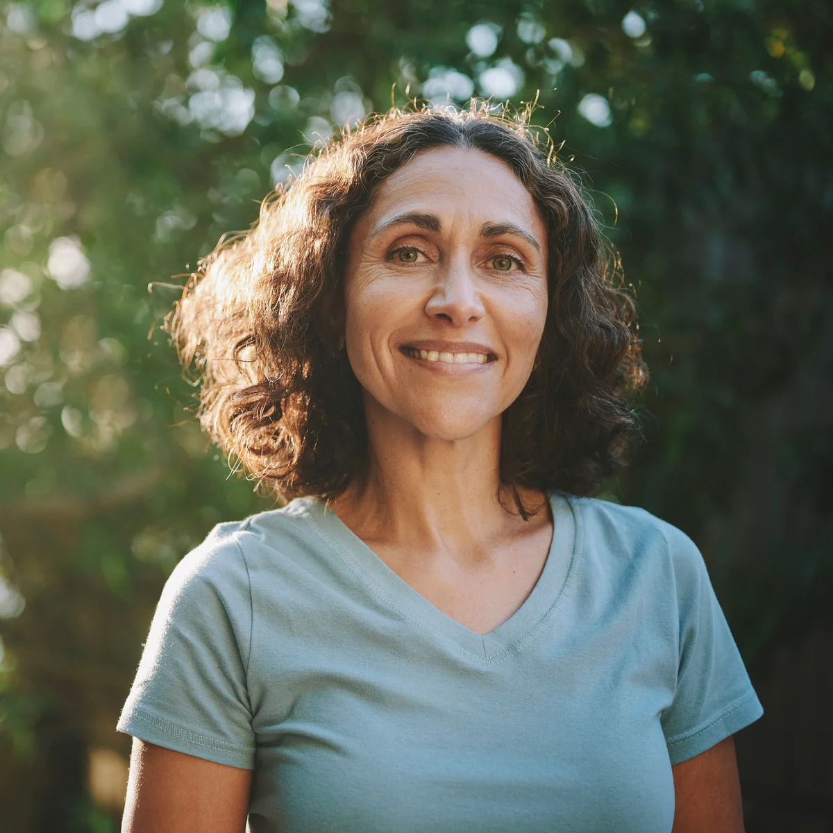 Smiling mature woman standing in a park outdoors in the summertime