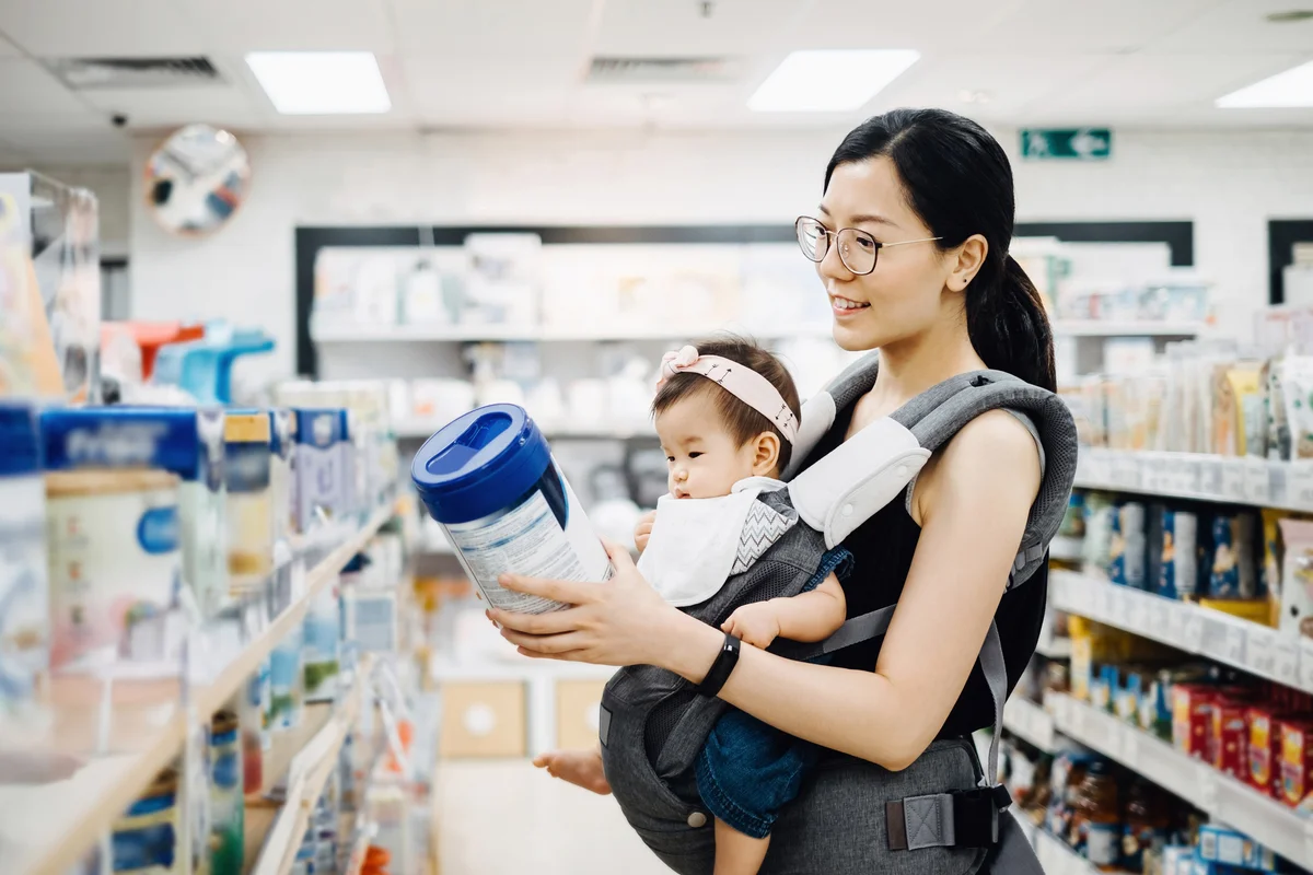 Mother carrying cute baby girl shopping