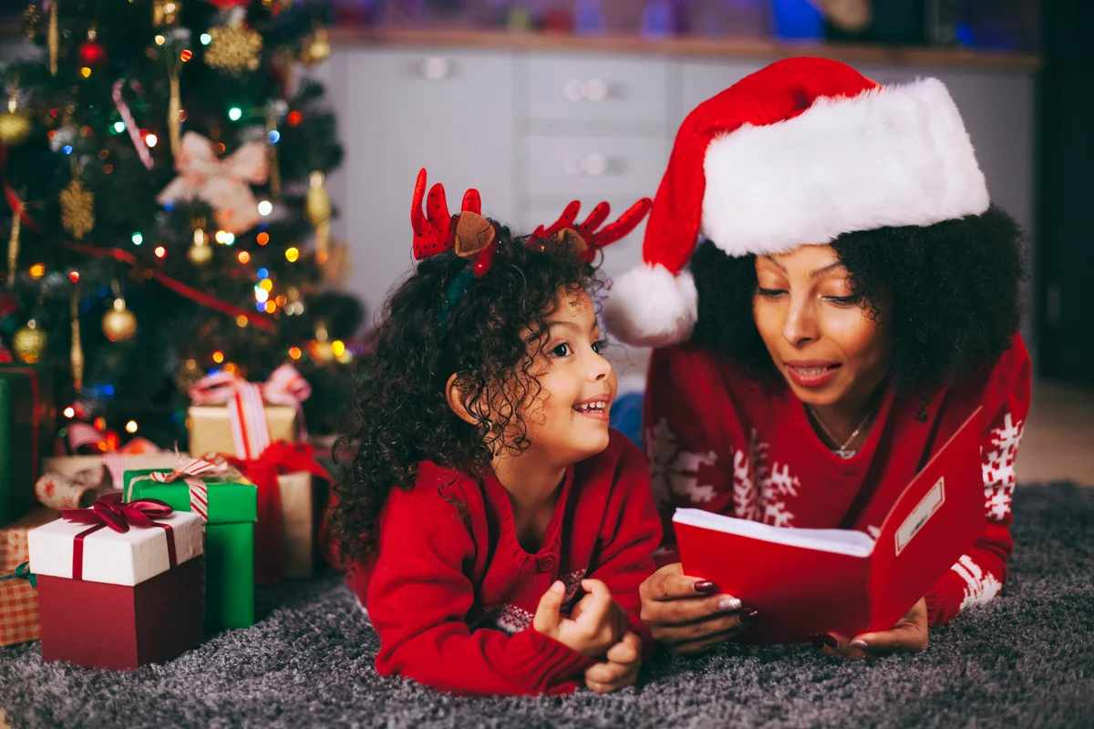 mother and child reading a story by the Christmas tree