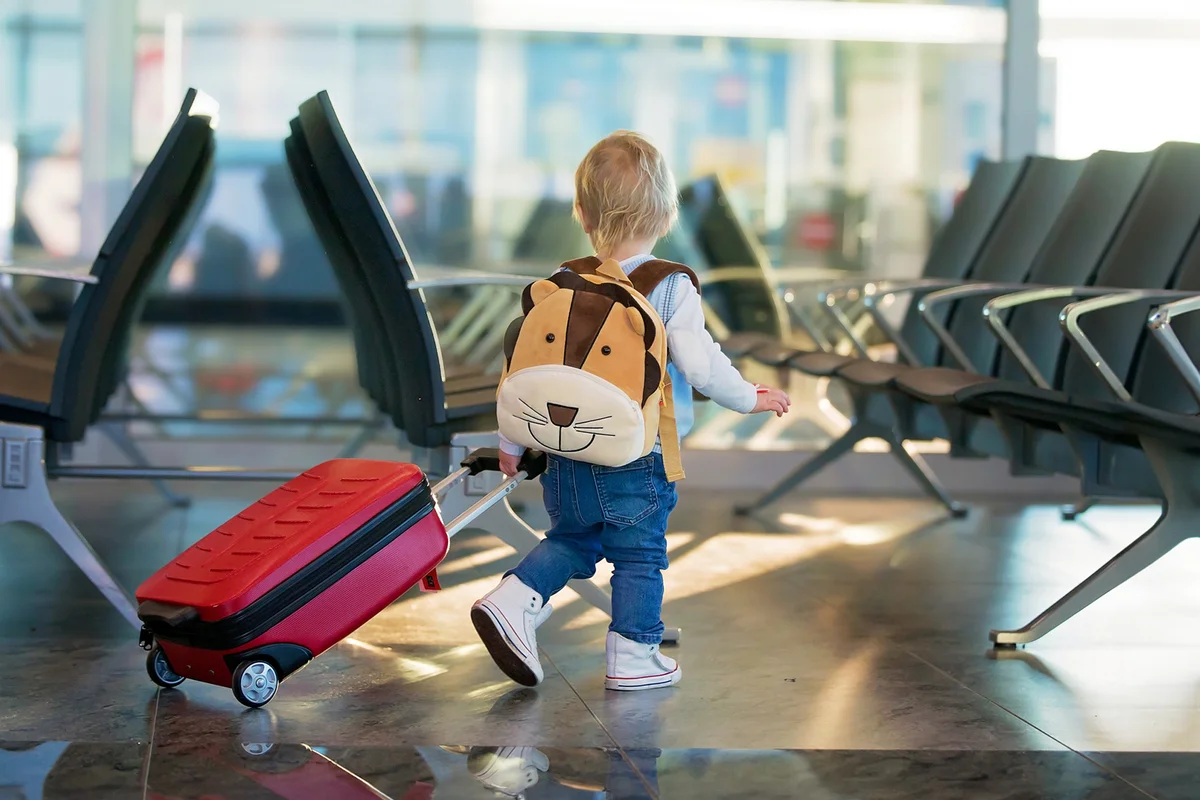 Children at the airport with suitcase