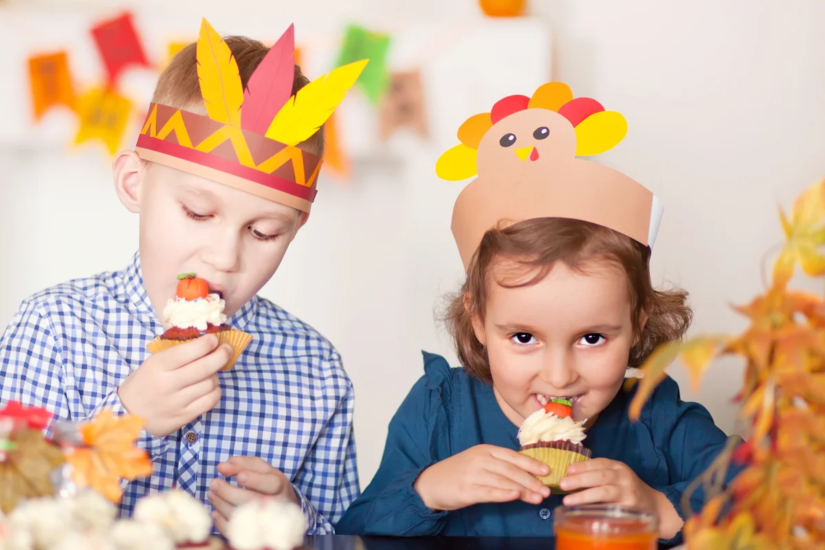 Kids sitting on festive table and celebrating Thanksgiving day