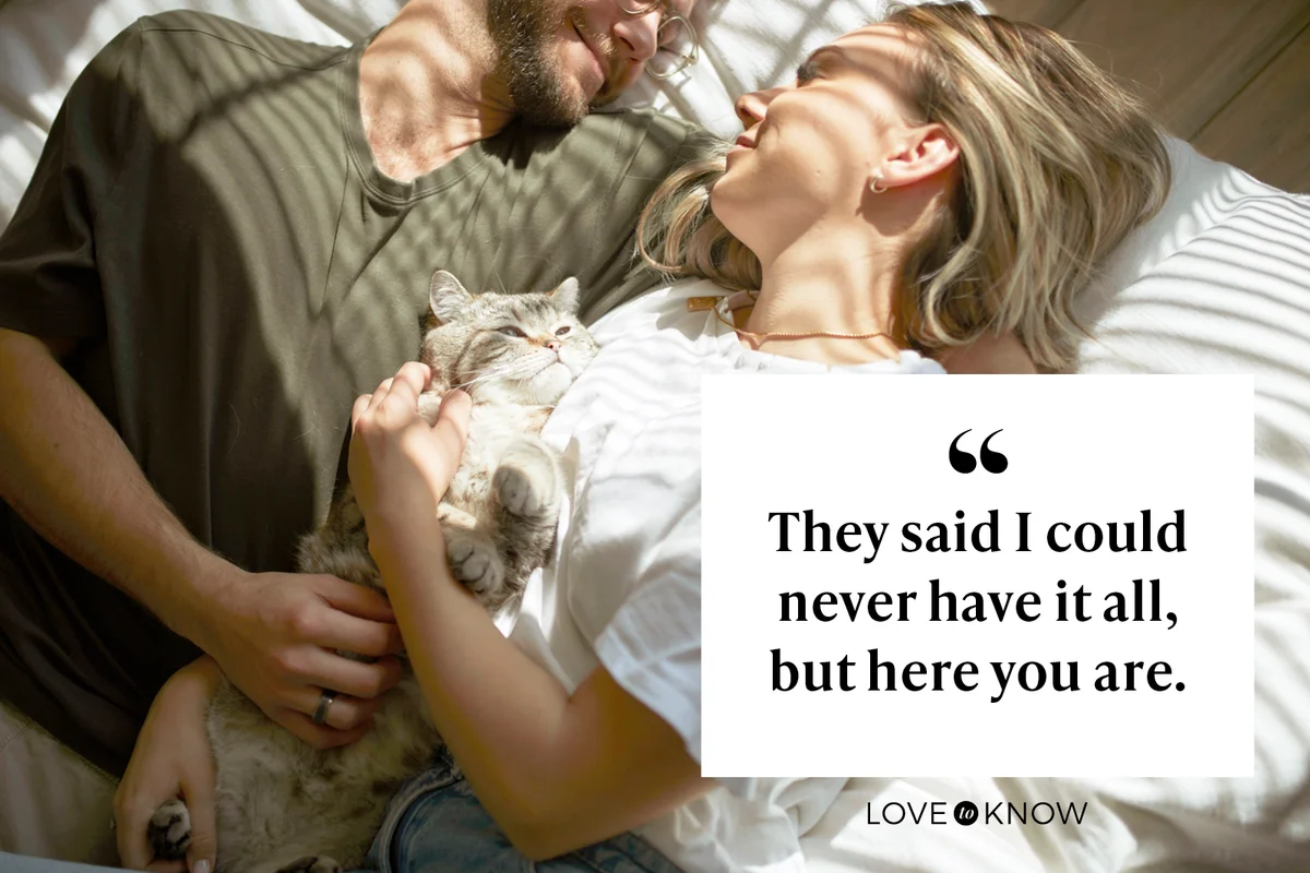 Couple laying in bed with their cat