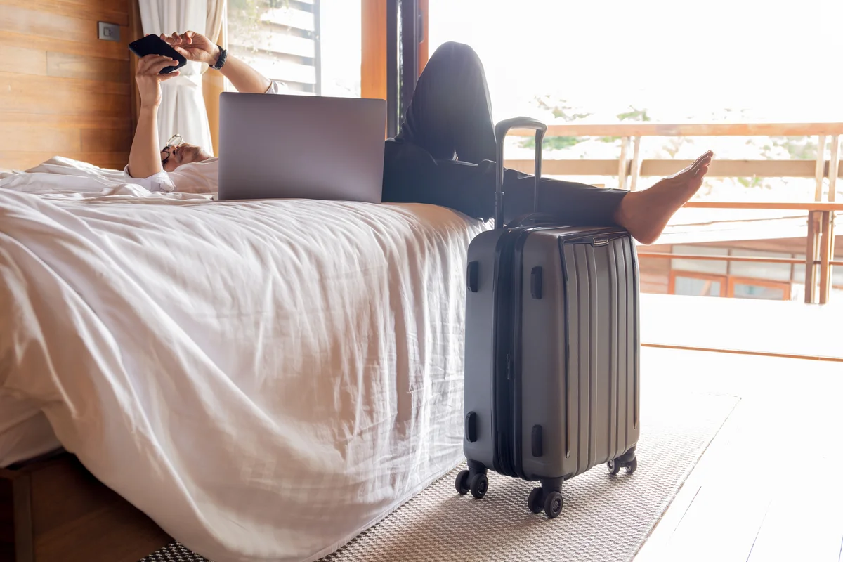 Relaxed businessman lying in hotel room bed