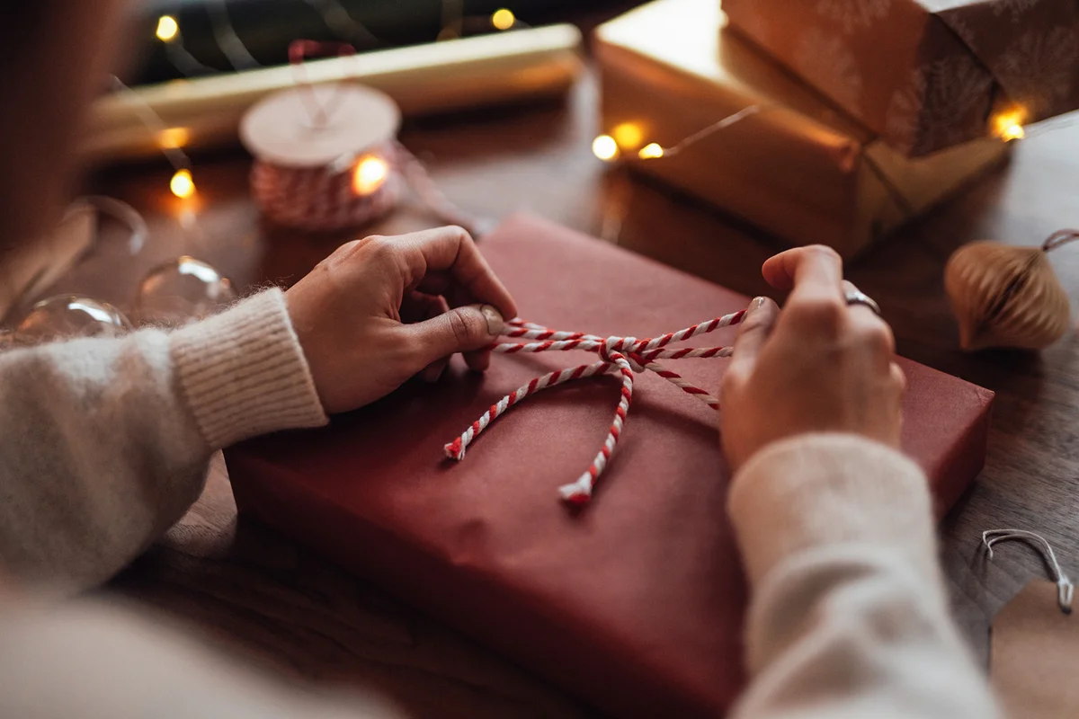 Over the shoulder view of young woman wrapping Christmas presents