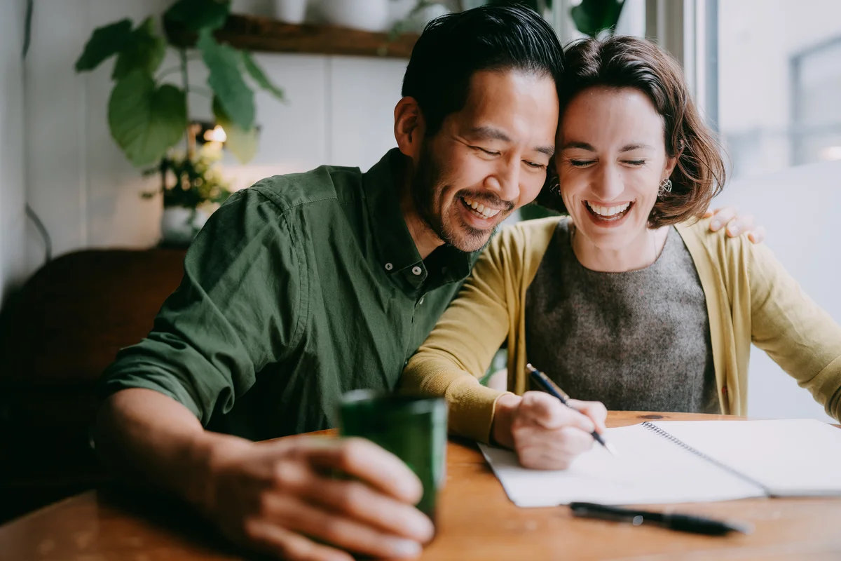 Couple writing together laughing
