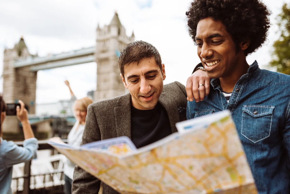 Tourists in london at tower bridge with map