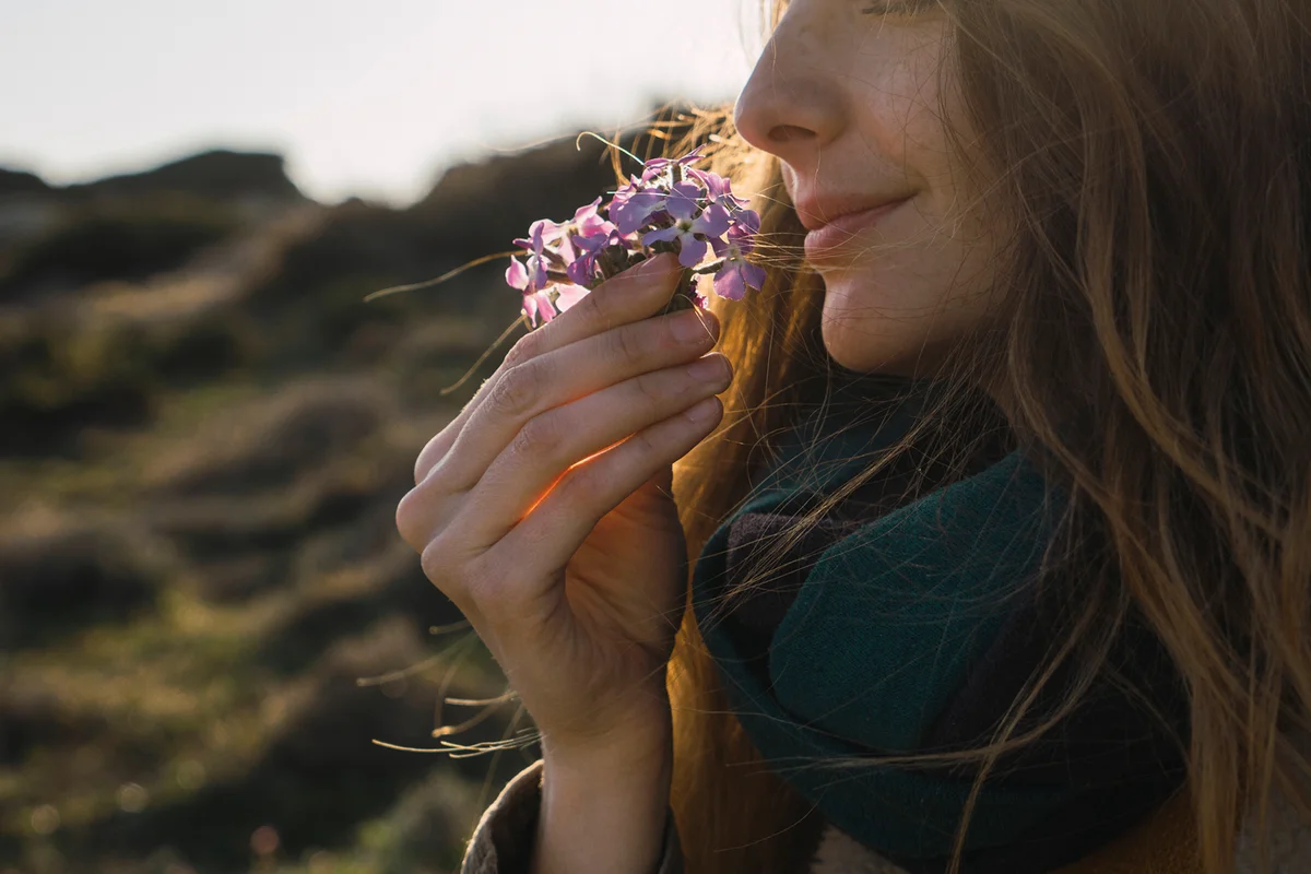 Woman enjoying fragrance of a flower
