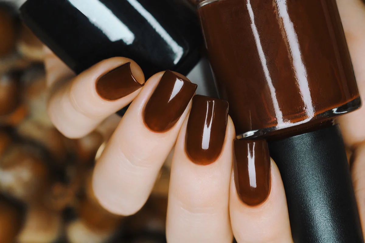 Brown manicure against the background of acorns and nuts