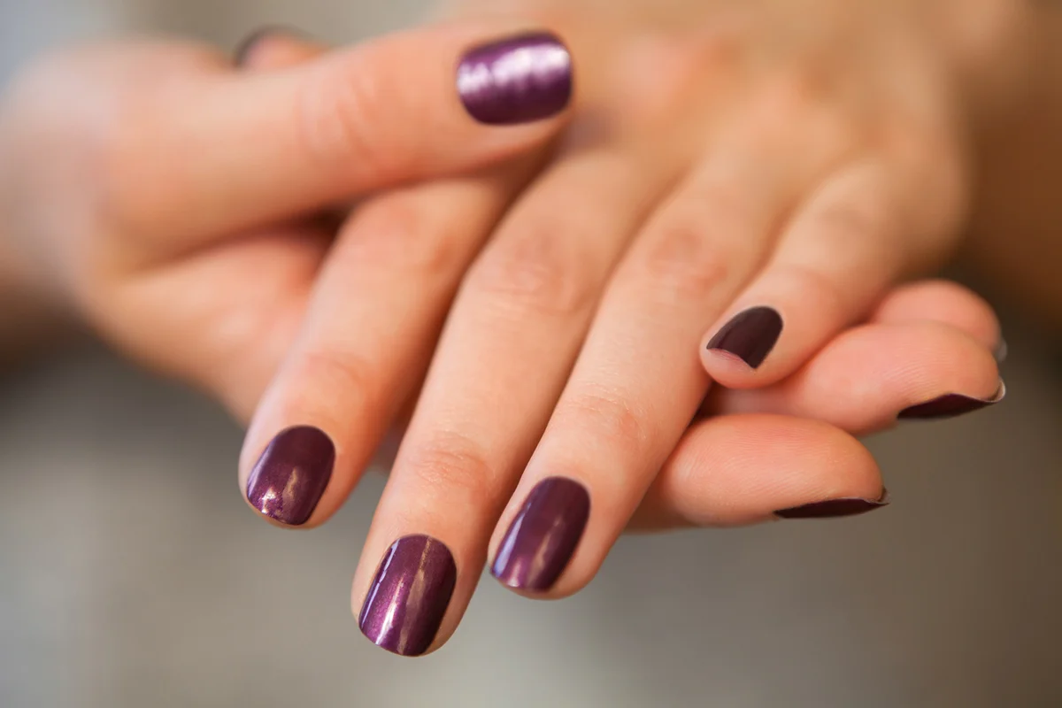 Pair of elegant hands with purple nail paint