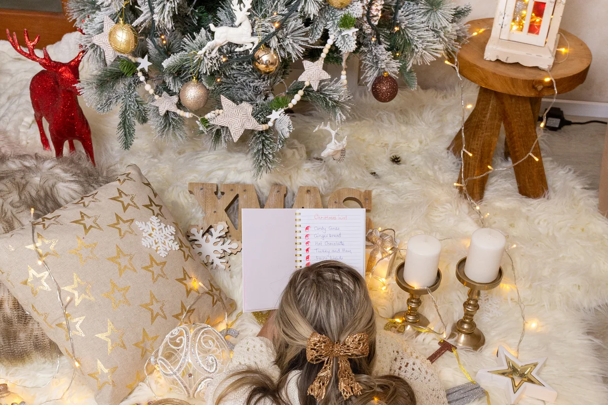 Woman lying in front of the Christmas tree with Christmas decorations all around her