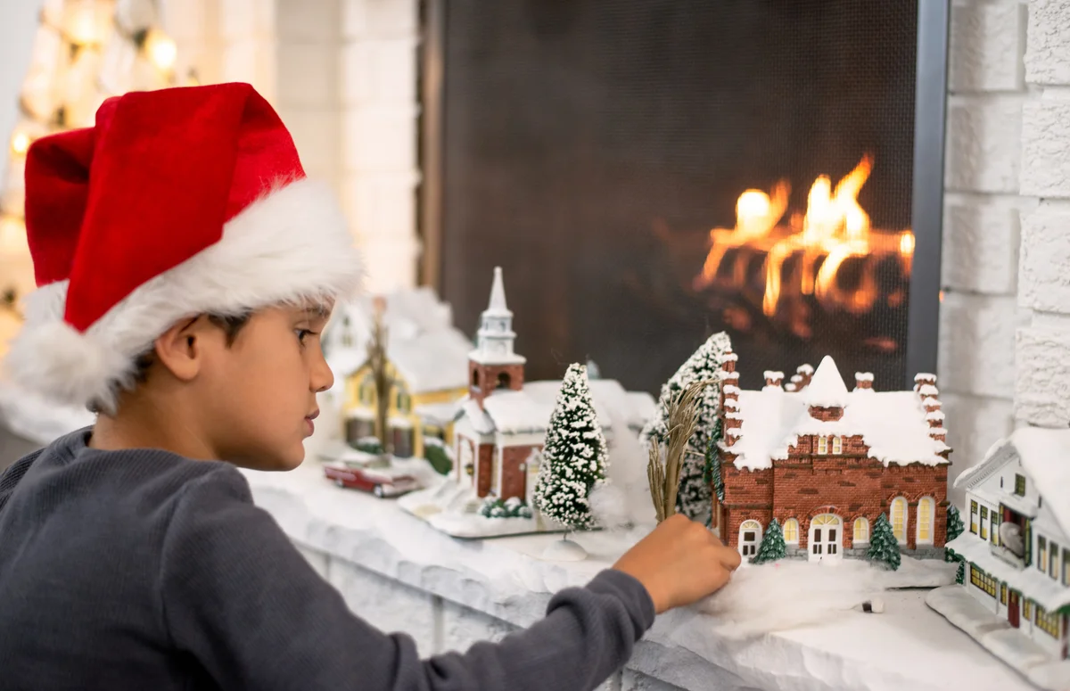 Boy Setting Up The Christmas Village Display