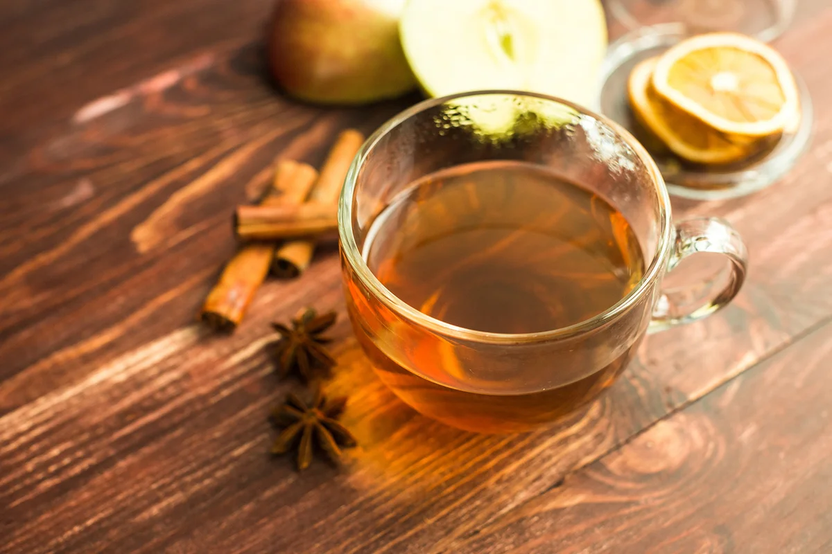 Cup of tea on wooden background with cinnamon