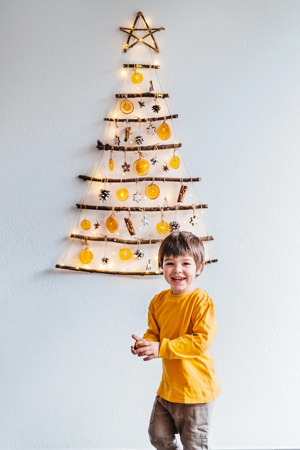 Kid playing with handmade craft Christmas tree
