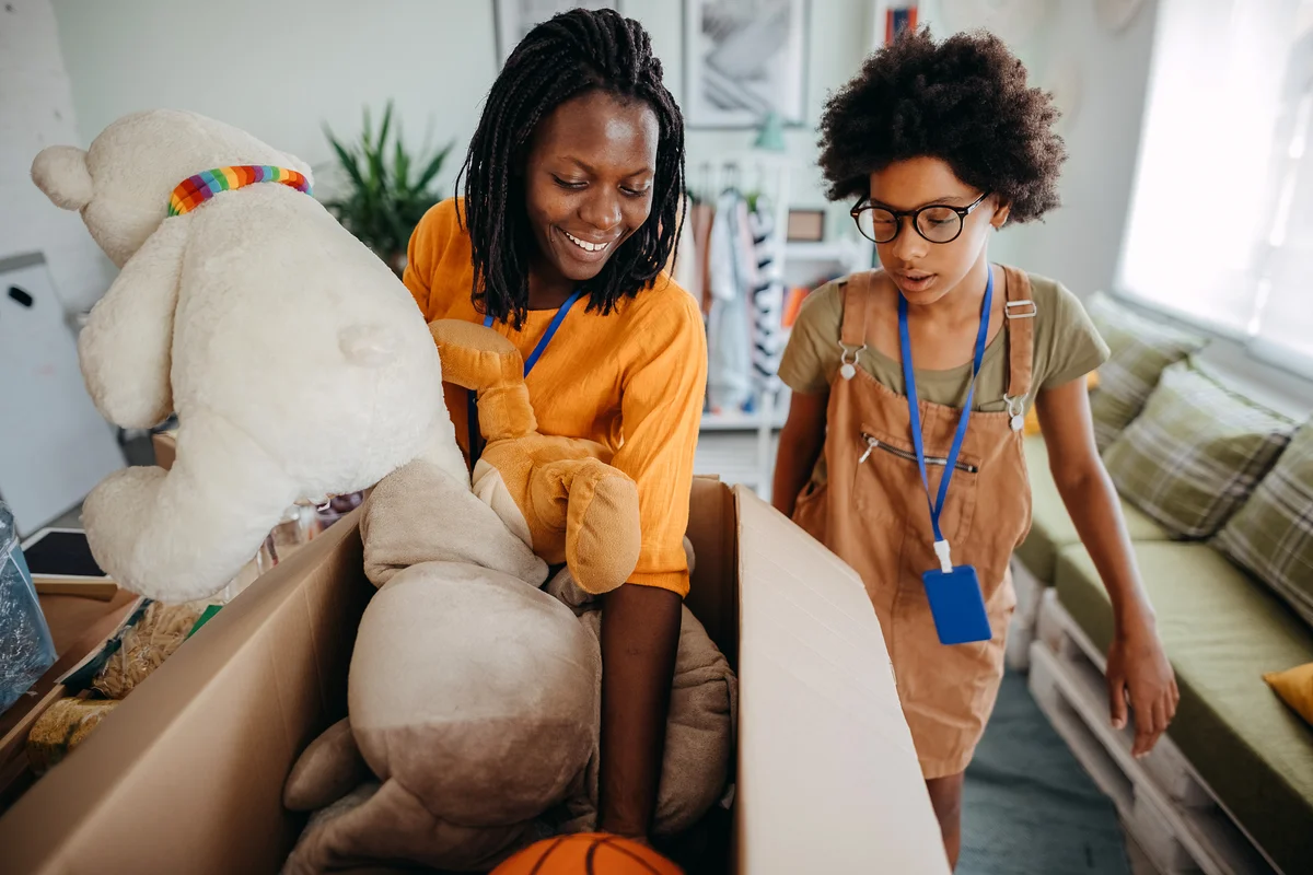 Two women pack toys and prepare for donation