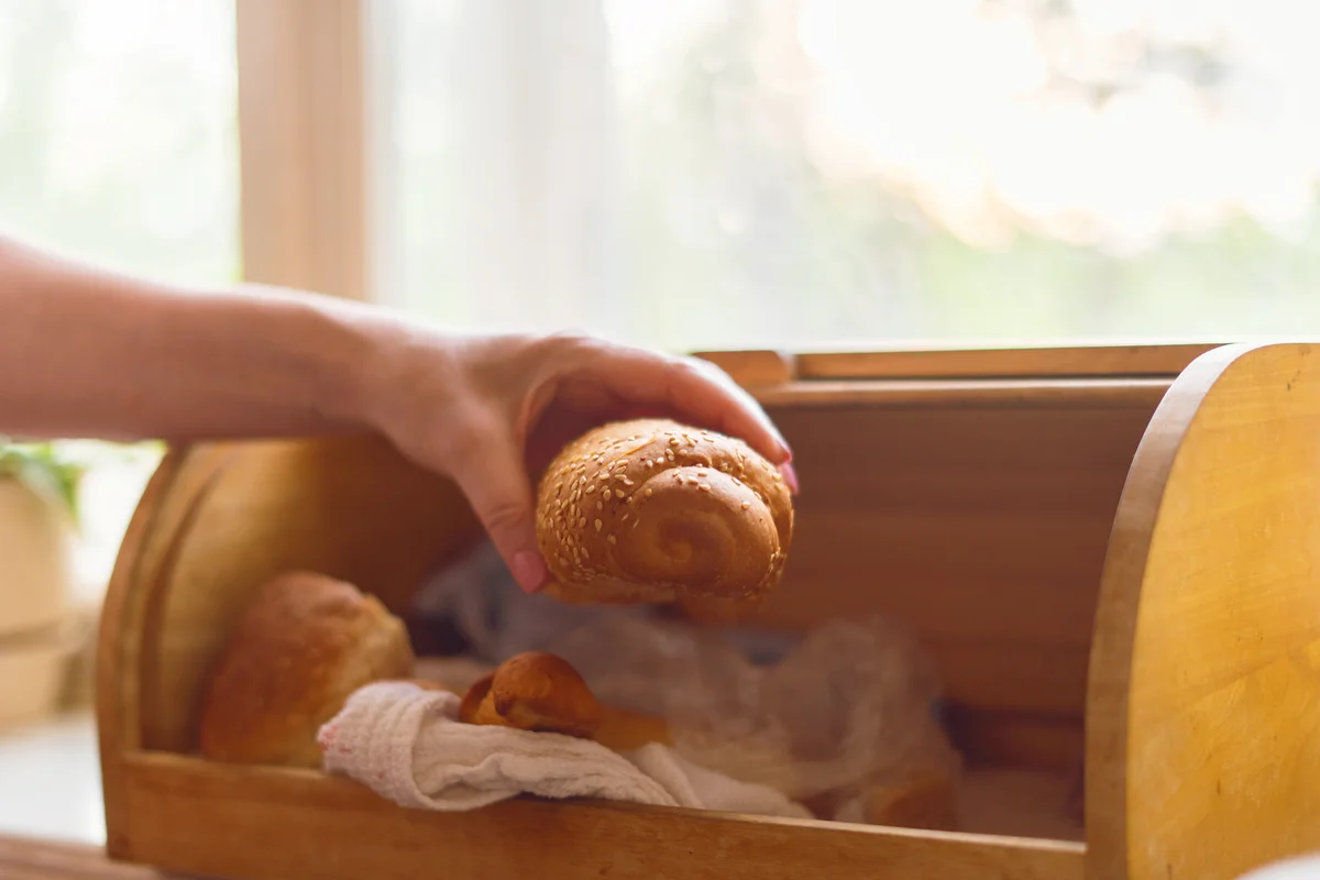 Woman taking a bread loaf from a bread box