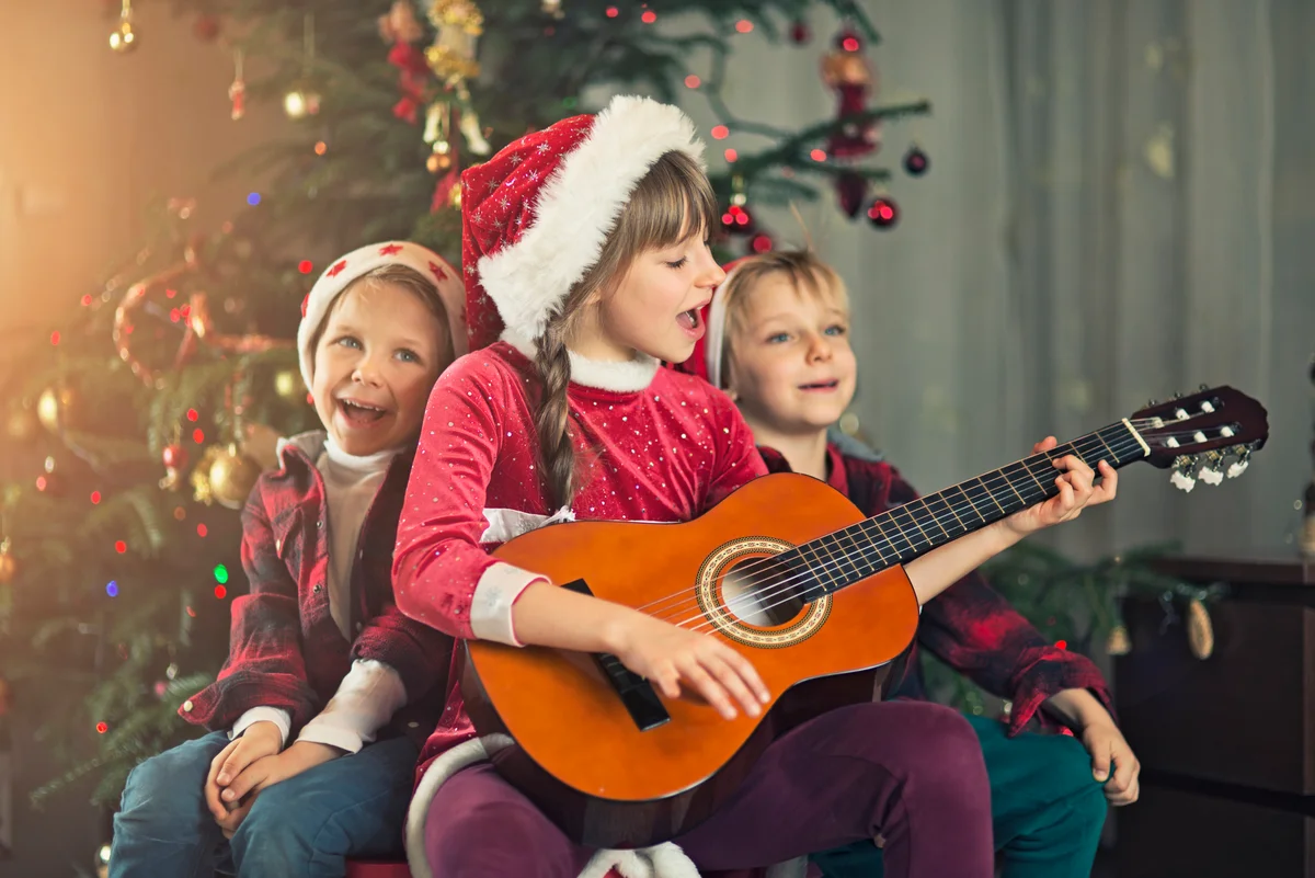 kids singing by a Christmas tree
