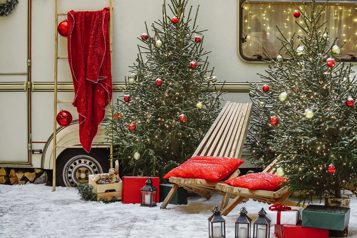 New Year's photo zone with decorated Christmas trees near the trailer