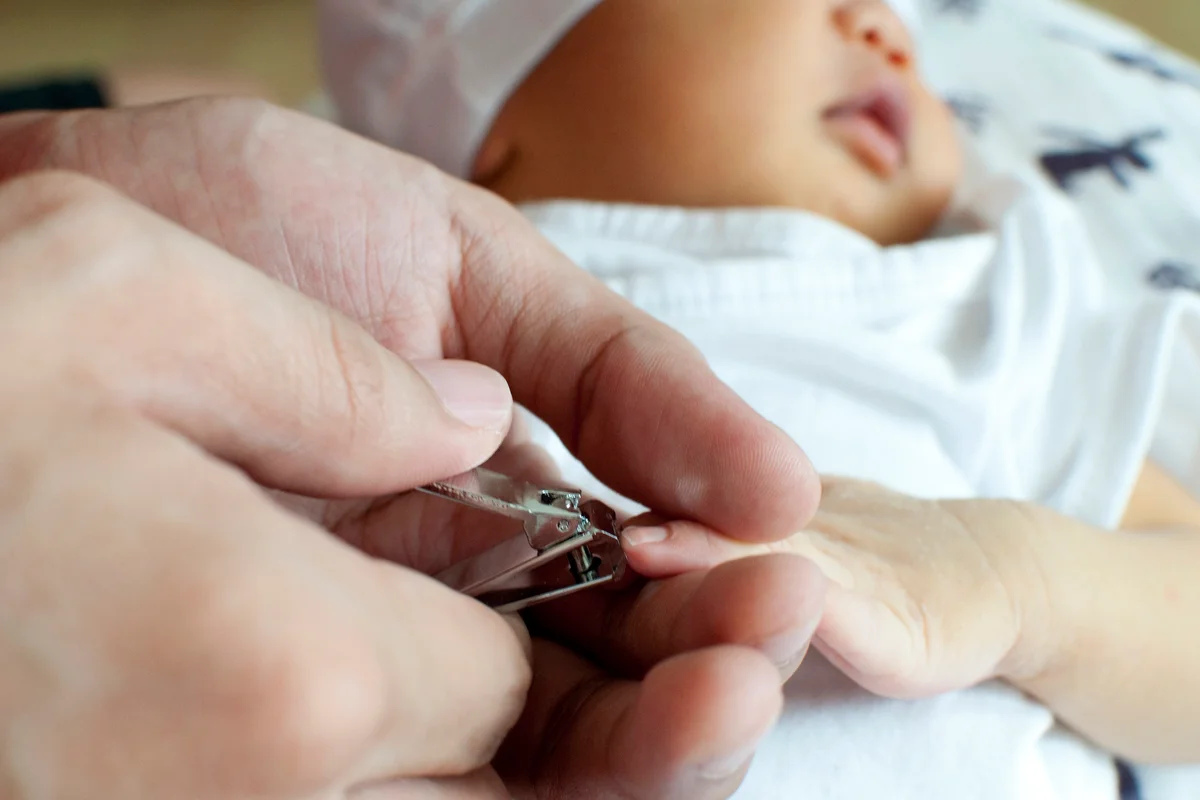 Cutting the nails of a newborn baby