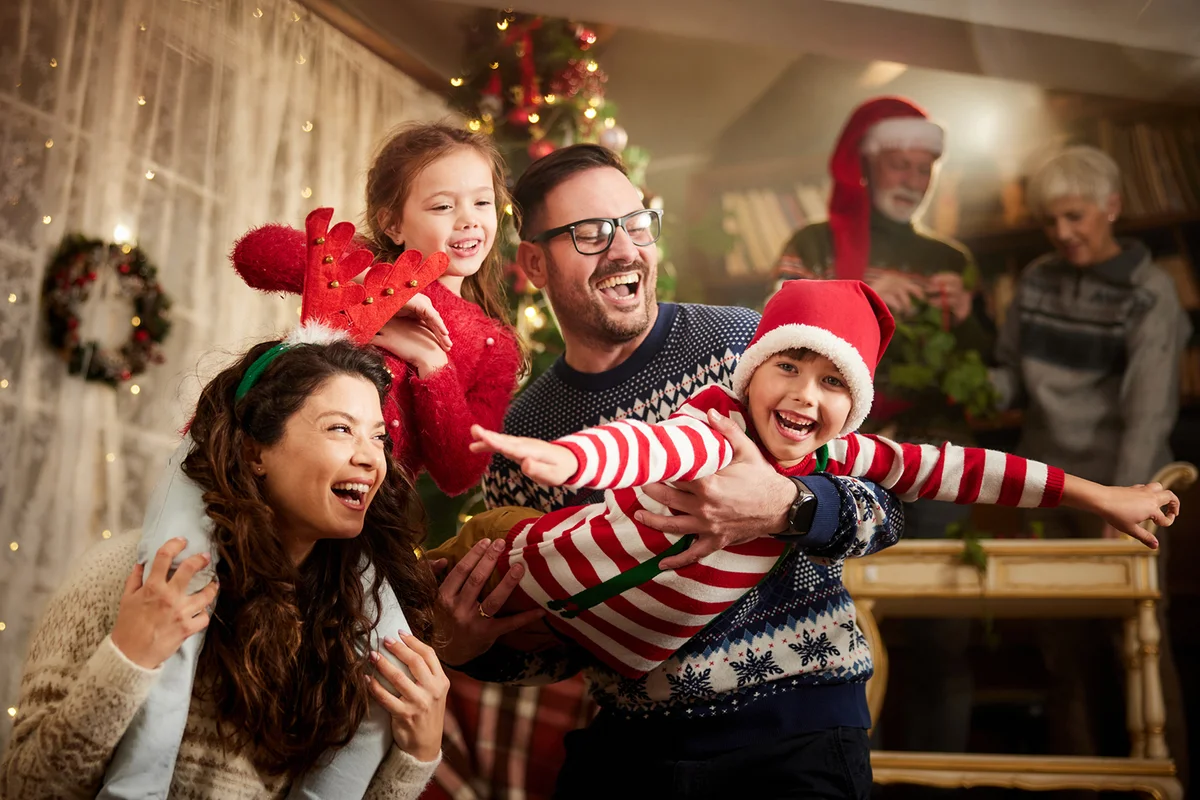 Young playful family having fun on Christmas eve at home