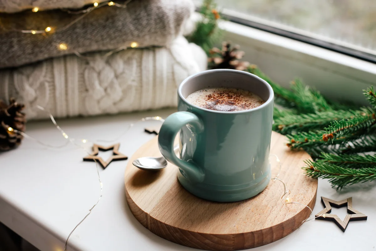 Cozy home picture of blue ceramic cup with coffee on window sill
