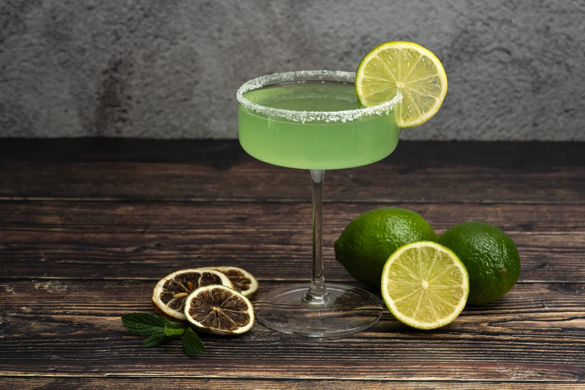 Margarita cocktail with dried lemon slices on wooden table