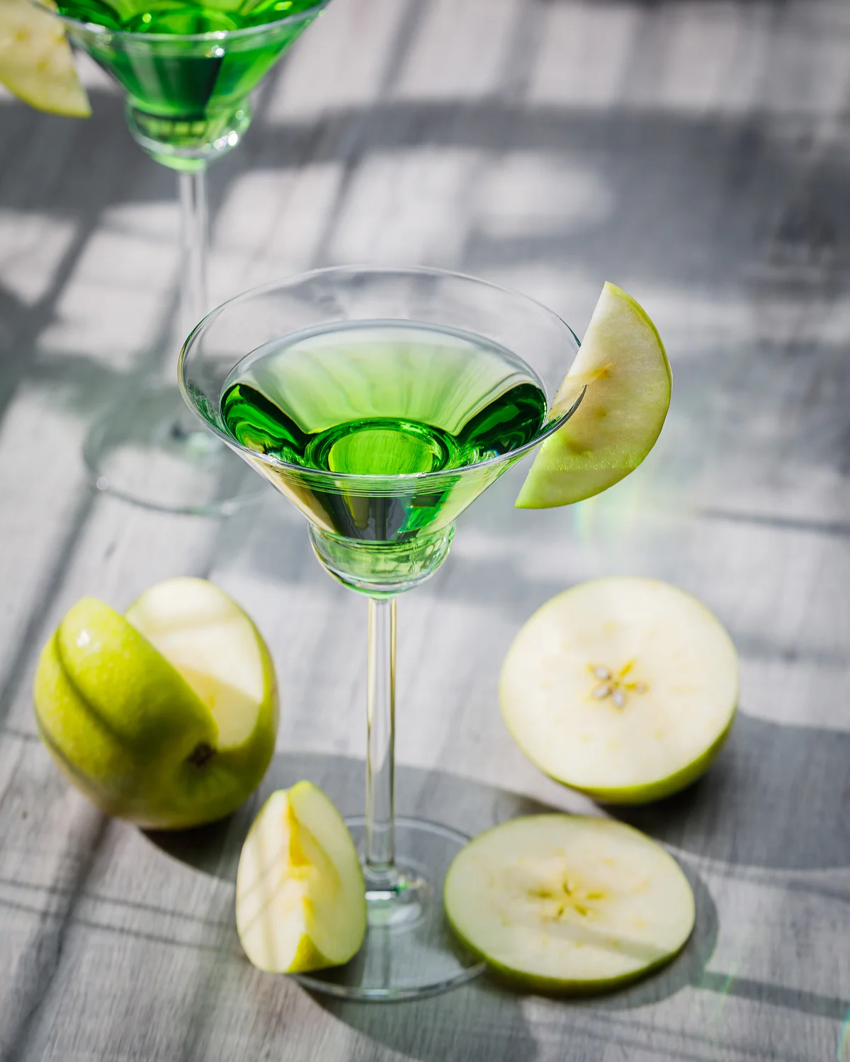 Appletini cocktail, apple martini cocktail garnished with green apple