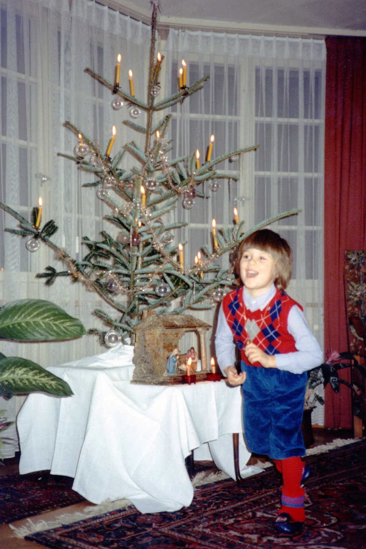 Boy in front of christmas tree with candles