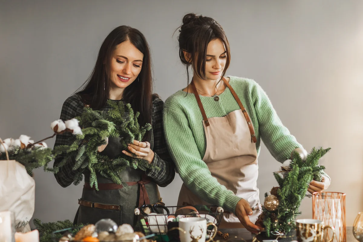 Two women making Christmas wreath