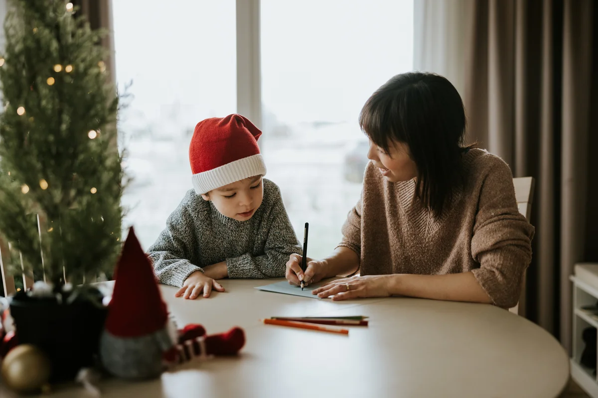 Mother and son writing christmas cards together