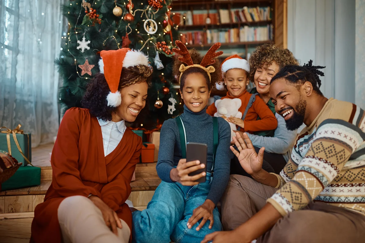 Family using smart phone while making video call on Christmas day